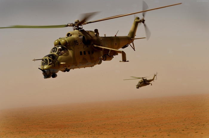 Mil Mi-35 attack helicopters flying over a desert