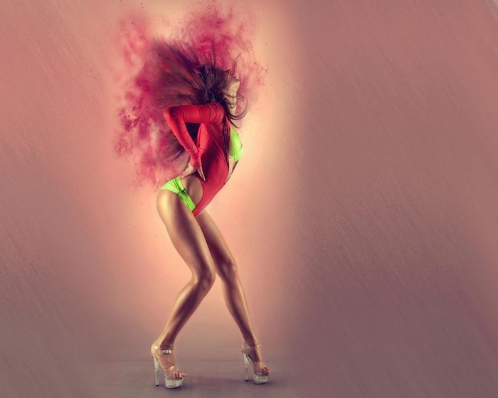 Woman in red and green leotard dancing with pink powder explosion