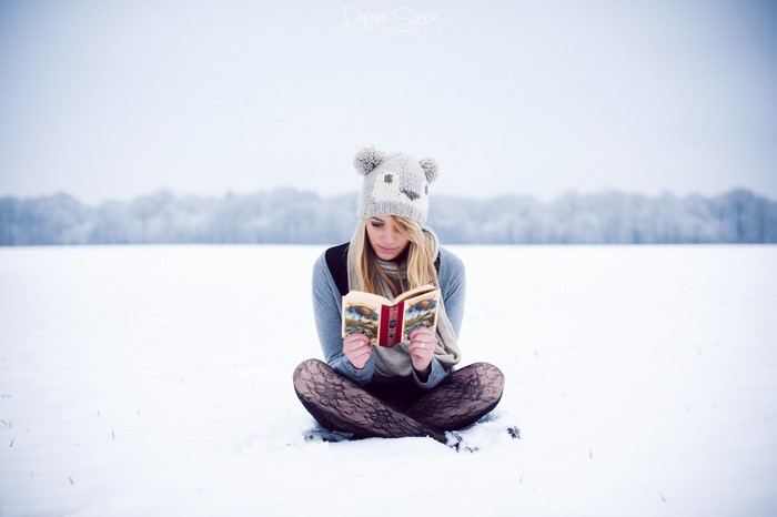 Woman reading a book in the snow
