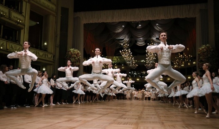 Ballet dancers in white costumes performing on stage