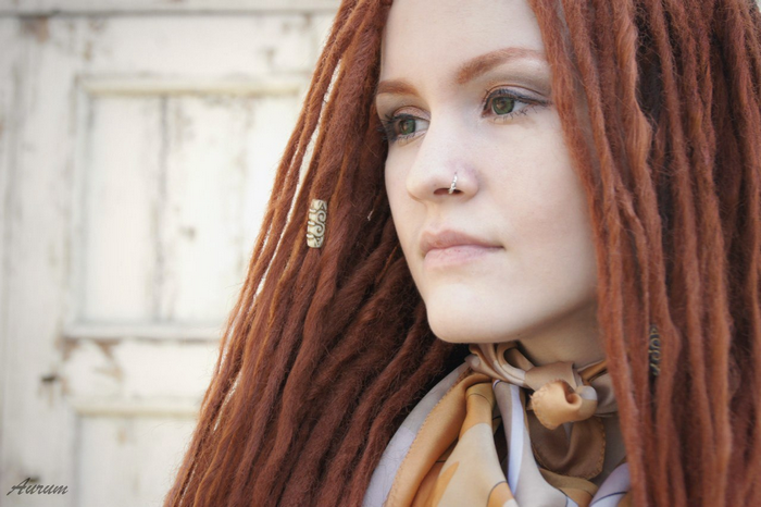 Woman with red dreadlocks and nose piercing