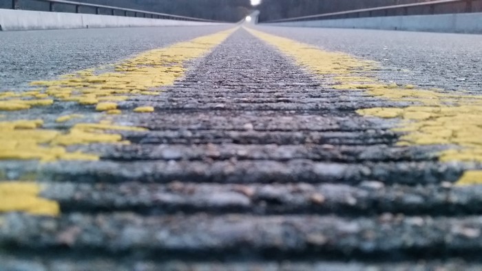 Worm's eye view of a road with yellow lines