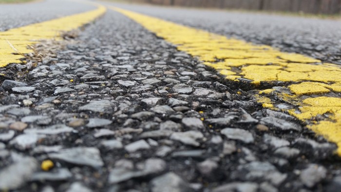 Close-up of asphalt road with yellow line