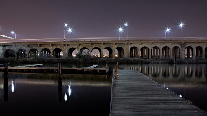 Bridge with arches over water at night with reflections