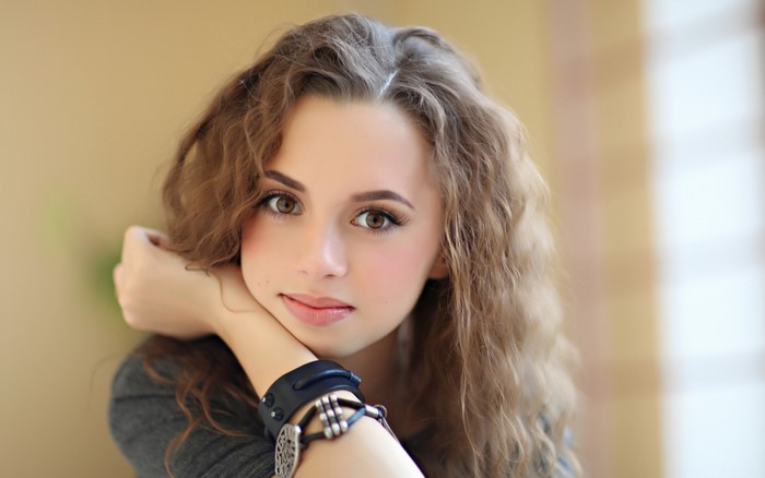 Young woman with curly brown hair and brown eyes