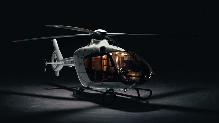 White helicopter with tinted windows on a dark surface