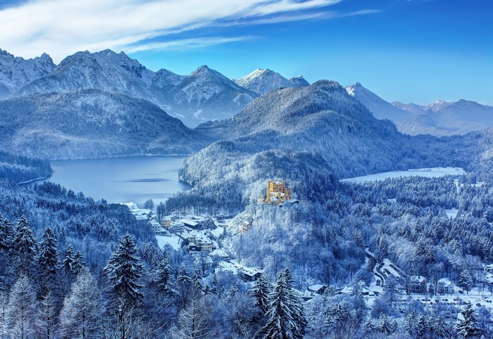Snowy mountains and lake with a castle in Germany