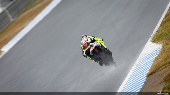 Valentino Rossi racing a motorcycle in the rain