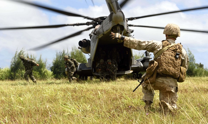 Marines disembarking from a helicopter during a landing operation