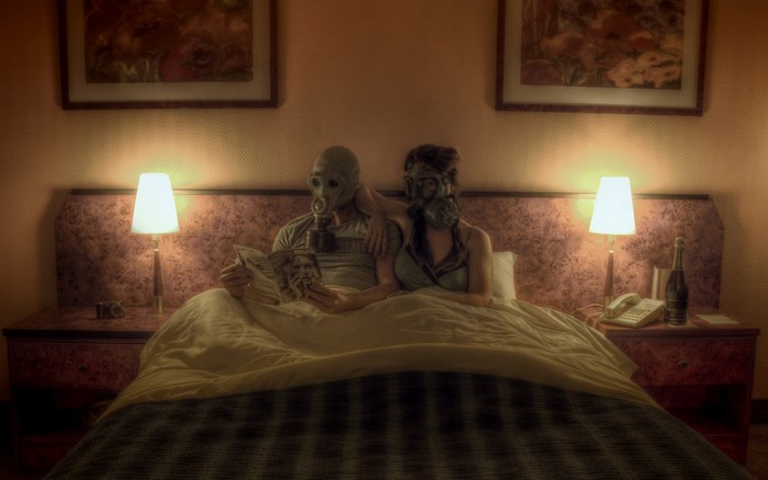 Couple in gas masks in a bedroom