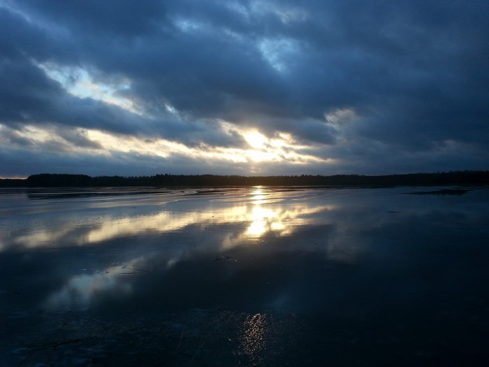 Sunset over a frozen lake with dark clouds