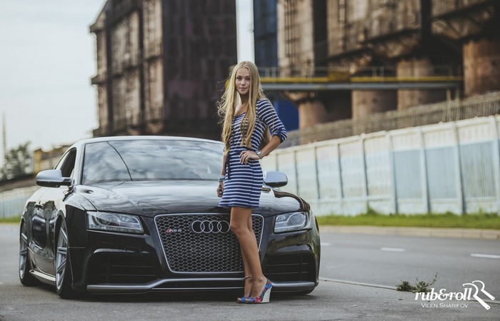 Woman in striped dress posing with black Audi RS5