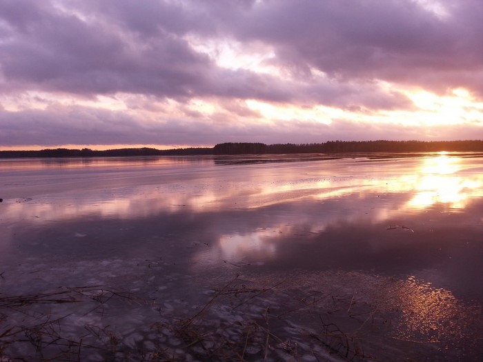 Sunset over a frozen lake with clouds