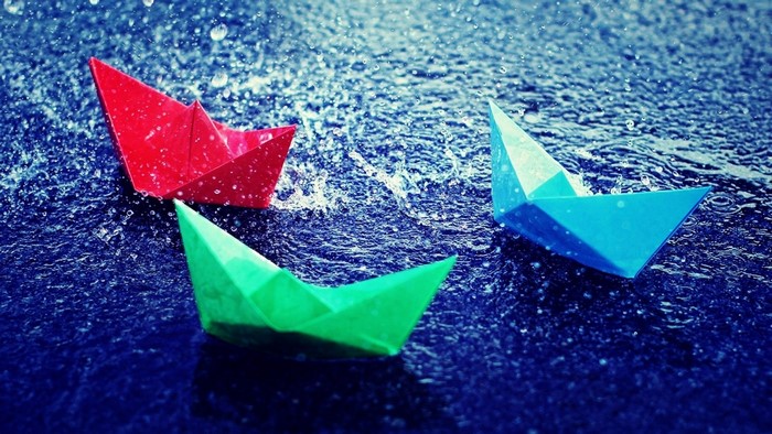 Origami paper boats floating in the rain