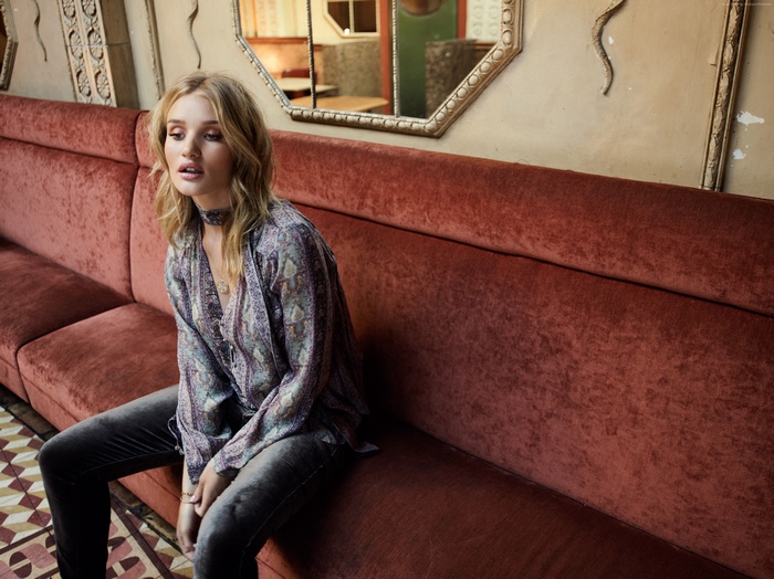 Rosie Huntington-Whiteley sitting on a velvet couch