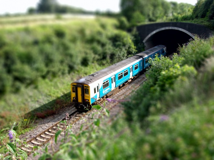 Blue and yellow train entering a tunnel