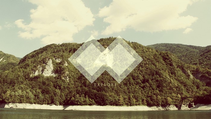 Geometric shapes over forested mountains and lake
