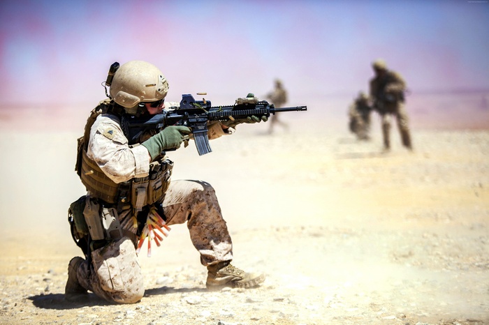 Soldier firing an M4 carbine in the desert