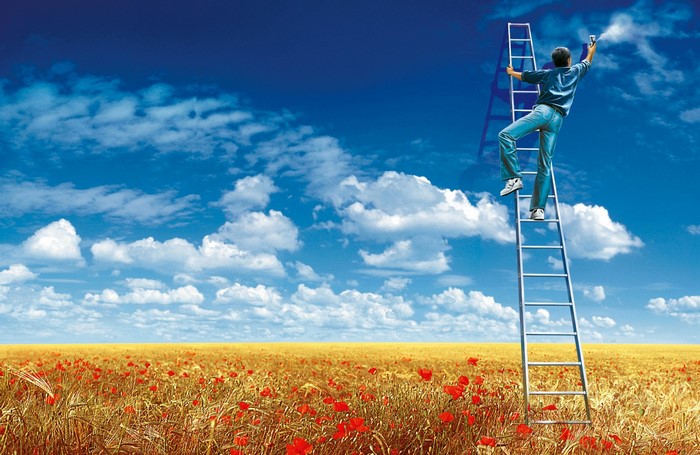 Man climbing ladder in wheat field under blue sky