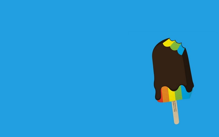 Chocolate-covered rainbow popsicle with a bite taken out