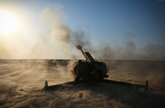 Artillery firing a 122-mm howitzer in the desert