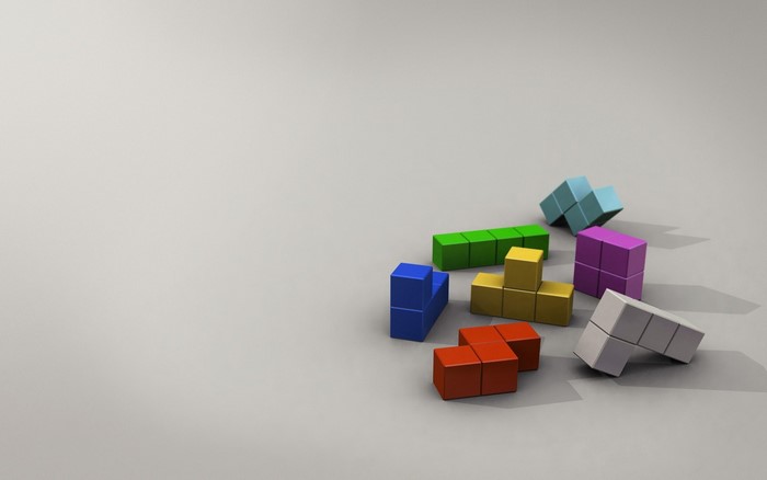 Colorful Tetris blocks scattered on a gray surface