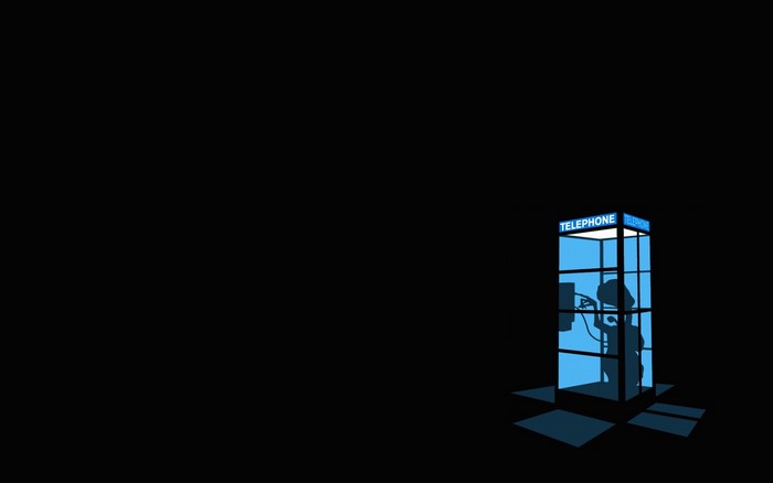 Silhouette of a person in a blue telephone booth
