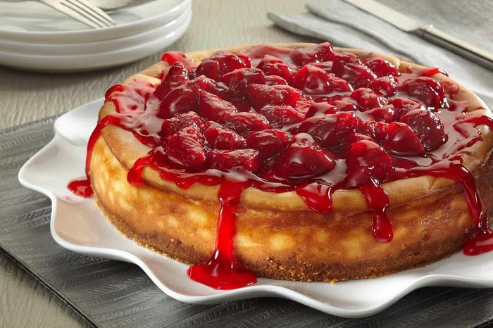 Cheesecake with cherry topping on a white plate