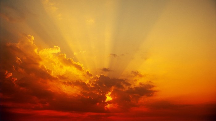 Sunbeams shining through clouds at sunset