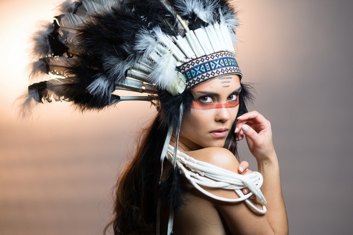 Woman wearing a Native American headdress and face paint