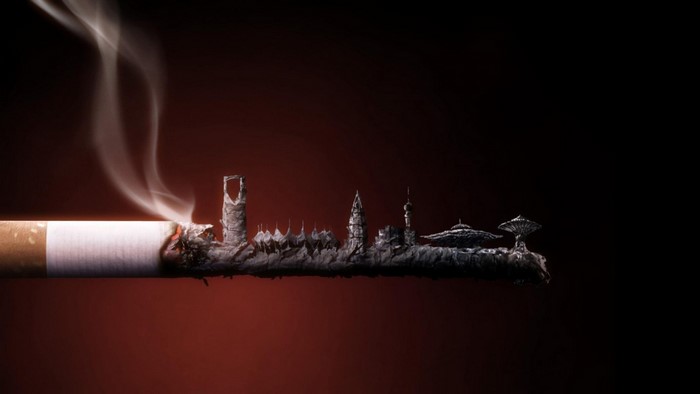 Cigarette ash forms a city skyline with smoke