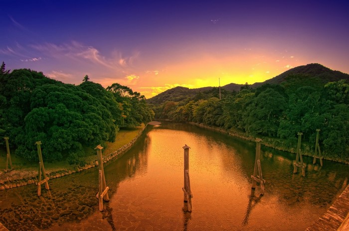 River landscape at sunset with trees and hills
