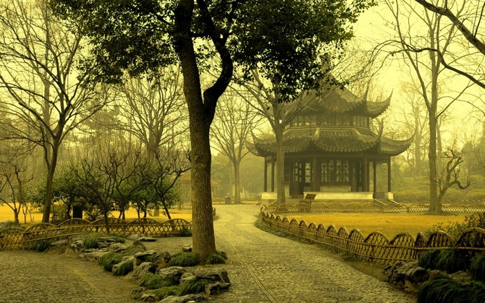 Asian pavilion in a park with trees and a path