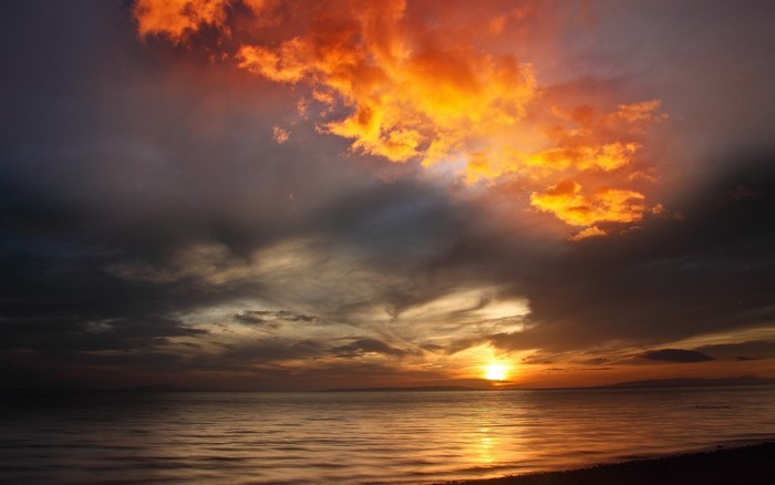 Sunset over the ocean with dramatic clouds