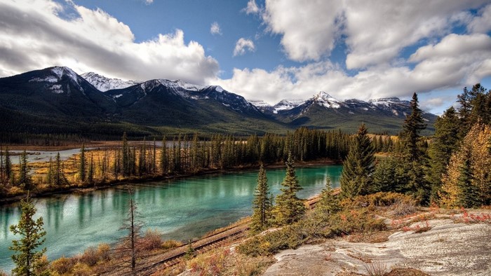 Turquoise river and snow-capped mountains in autumn