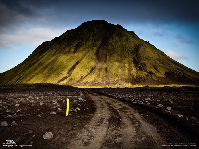 Moss-covered mountain and dirt road in Iceland