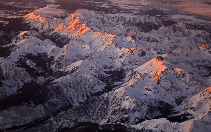 Snow-covered mountains illuminated by golden hour light