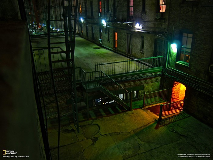 Urban alleyway at night with fire escapes
