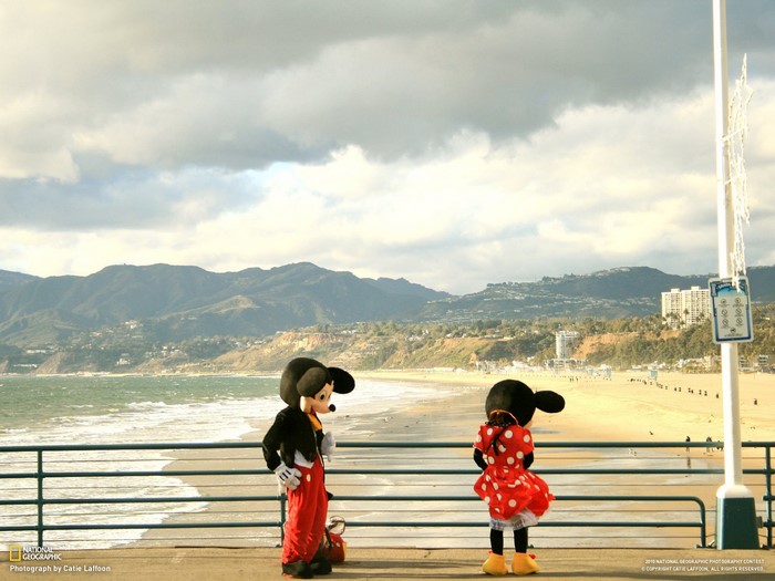 Mickey Mouse and Minnie Mouse on a pier overlooking the ocean