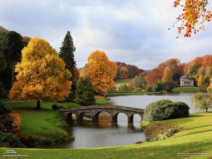 Autumn landscape with a stone bridge over a pond