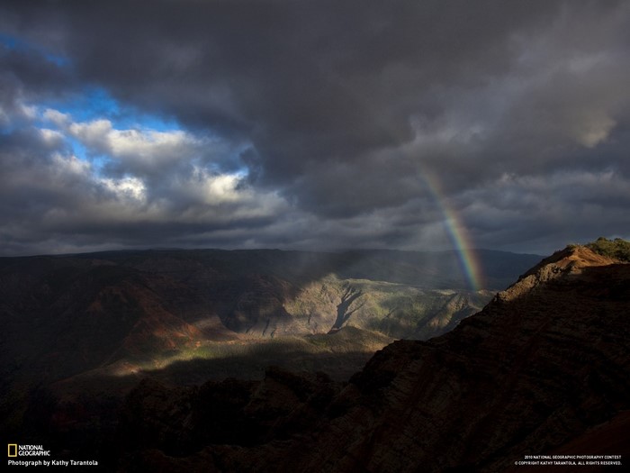 Rainbow over a canyon at sunset