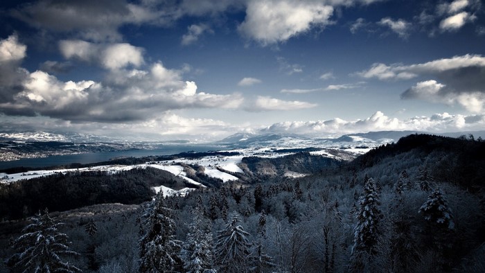 Snowy mountain landscape with lake and clouds