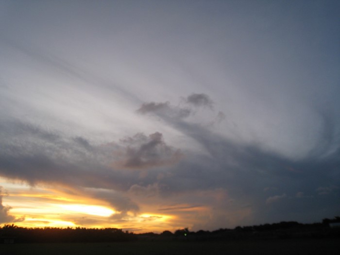 Sunset sky with clouds over a dark horizon