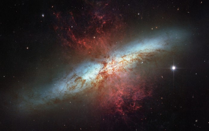 M82 galaxy with red nebula and stars