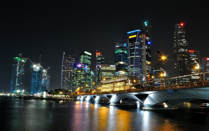 Singapore cityscape at night with illuminated skyscrapers and bridge