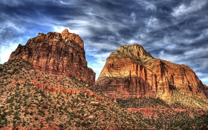 Two large sandstone mountains under a cloudy sky