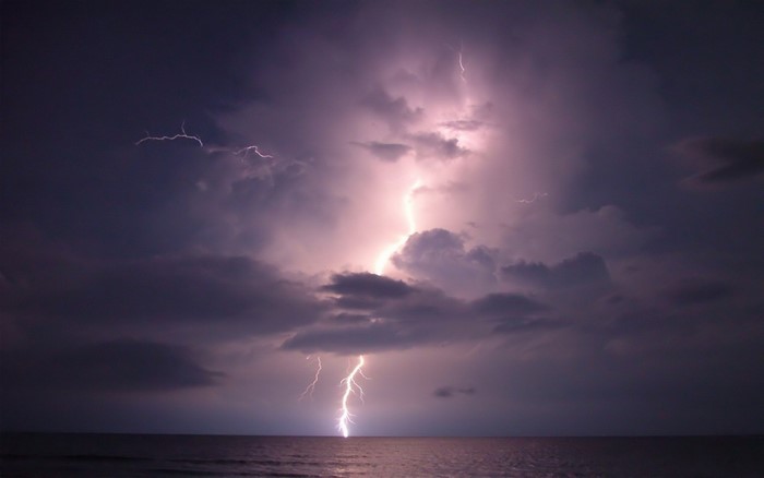 Lightning strikes the ocean during a thunderstorm