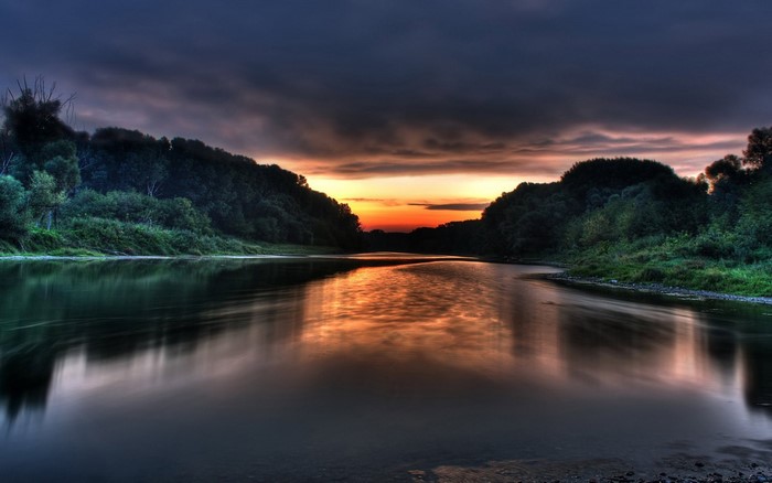 River landscape at sunset with forest and reflection