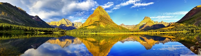 Mountain range reflected in a lake with autumn trees