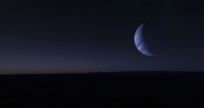 Planet in the night sky over a dark landscape